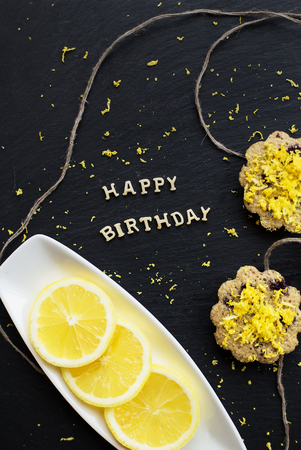 lemon cupcakes on a black background - inscription happy birthdayの写真素材