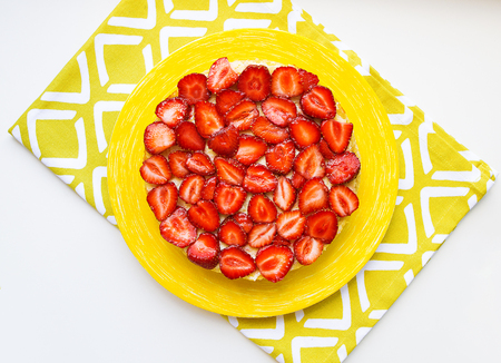 Beautiful and delicious strawberry cake stands on a yellow napkin.の写真素材