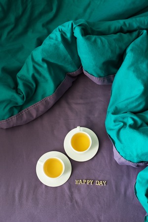 two cups of green tea on the bed inscription happy dayの写真素材