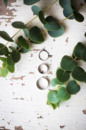 beautiful old ring on a white table with a sprig of eucalyptusの写真素材