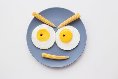 cheerful breakfast, two funny eggs on a plateの写真素材