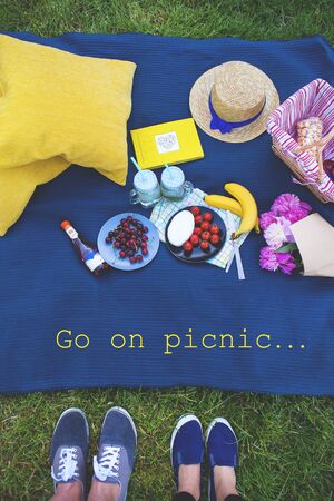 Bright picnic on the nature-flowers, delicious food, a loving coupleの写真素材