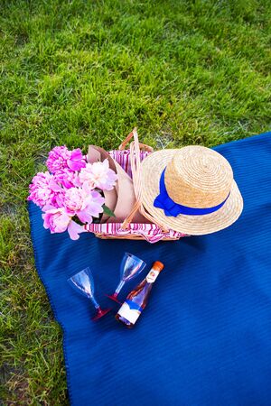 Beautiful flowers in a basket stand on the grass-picnicの写真素材
