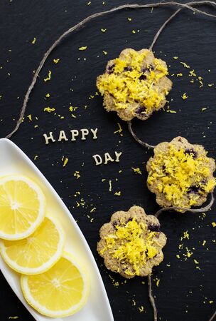 lemon cupcakes on a black background - inscription happy dayの写真素材