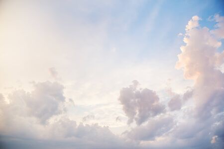 blue sky with a big cloud coating with orange sunset light.の写真素材
