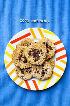 Oatmeal cookies with chocolate on blue napkin inscription good morning.の写真素材