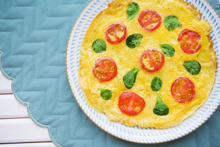 omelet with cherry tomatoes and basil on a bright napkin.の写真素材