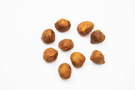 a scattered brown hazelnut on white background.の写真素材