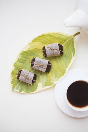 Two cups of coffee with a teapot stand on a table, candy made from nuts.の写真素材