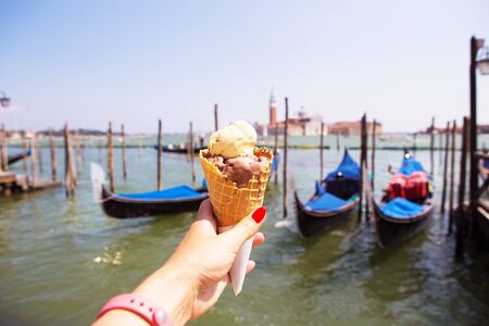 Beautiful sunny Venice, the girl is holding Italian ice cream.の写真素材