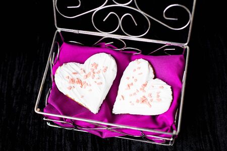 Cookies in the form of heart lies in a casket with a pink towel, close-up.の写真素材