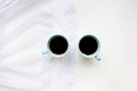 two cups of coffee with croissants on the background of laces on a white background, close-upの写真素材
