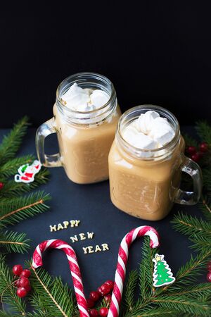 marshmellou cocoa, Christmas tree ornaments and candy on a black background. The inscription Happy New Year.の写真素材