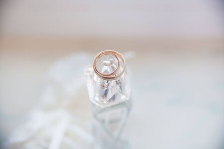 beautiful gold rings lie on a jar of perfumeの写真素材
