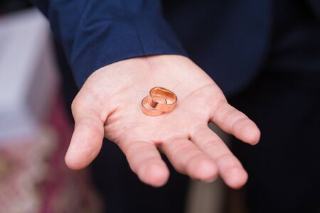 Wedding rings on the palm of the groom, marriage proposalの写真素材