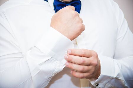 Groom buttons cuffs on his white shirtの写真素材