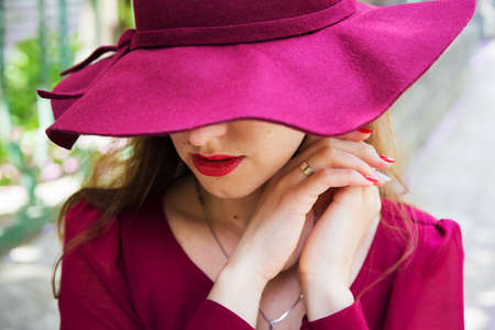 girl in the hat, red dress, hands close-upの写真素材