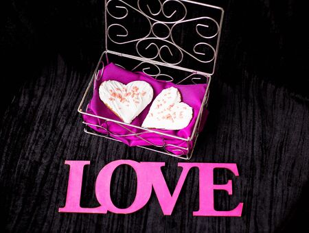 Cookies in the form of heart lies in a casket inscription love close-up.の写真素材