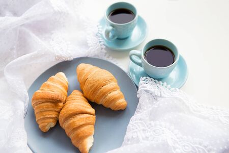 two cups of coffee with croissants on the background lacesの写真素材