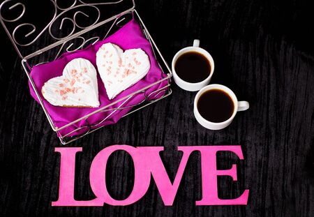 two cups of coffee, cookies in the form of heart inscription love.の写真素材
