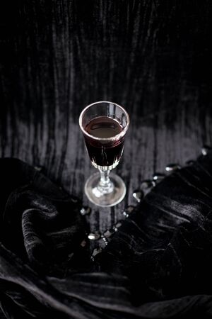 glass of red wine on a black velvet background, close-up.の写真素材