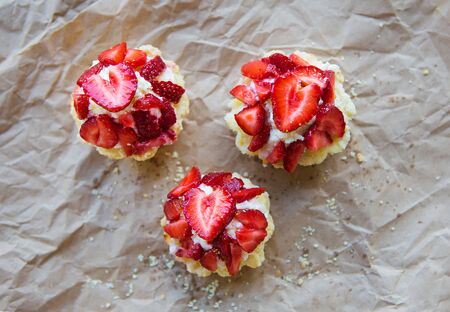 Very tasty muffins with fresh strawberries lie on kraft paper.の写真素材