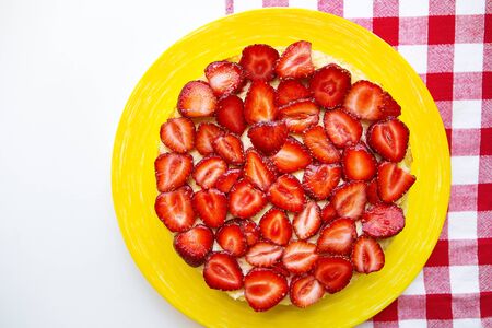 Bright and delicious strawberry cake on a red napkin in a cage.の写真素材