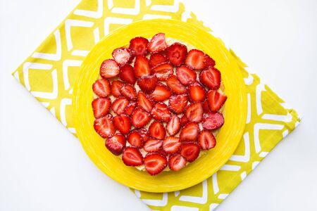 Beautiful and delicious strawberry cake stands on a yellow napkin.の写真素材