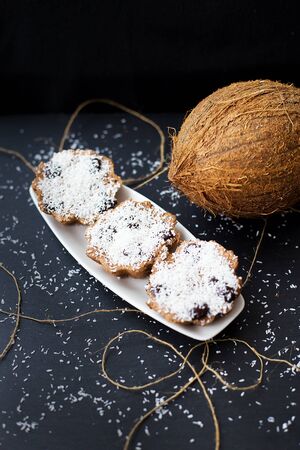 coconut muffins on a white plate with a whole coconut, close upの写真素材