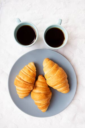 two cups of coffee with croissants on the background of laces on a white background, close-upの写真素材