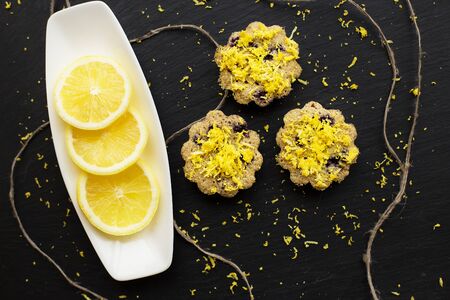 lemon cupcakes on a black background with lemon zestの写真素材