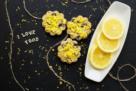 lemon cupcakes on a black background with lemon zest, inscription, I love foodの写真素材