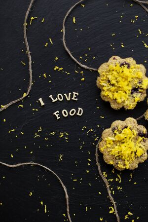 lemon cupcakes on a black background with lemon zest, inscription, I love foodの写真素材