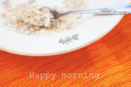 oatmeal in bowl on orange napkin that says happy morning.の写真素材