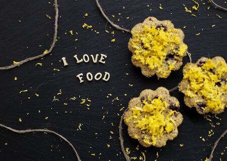 lemon cupcakes on a black background with lemon zest, inscription, I love foodの写真素材