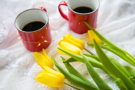 Beautiful morning, two cups of coffee and a bouquet of bright and beautiful tulipsの写真素材