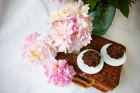 A very beautiful bouquet of pink peonies stands on a wooden suitcase. Beautiful composition. View from above.の写真素材