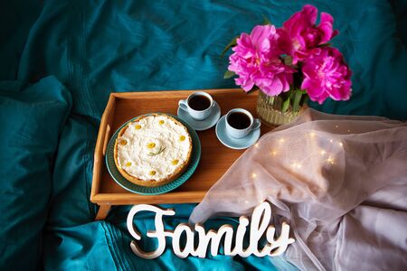 Beautiful morning Vanilla cheesecake, coffee, blue cups, pink peonies in a glass vase. View from aboveの写真素材