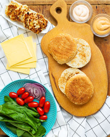 Preparation of all the ingredients for the preparation of a delicious bun burger, cutlet, cheese, salad, tomato, saucesの写真素材