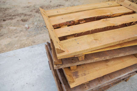 A lot of old wooden pallets stand on the street on top of each other, all for repairの写真素材