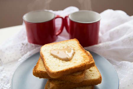 Homemade breakfast in bed. Toast with peanut butter, a cup of coffee. Good morningの写真素材