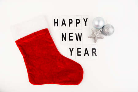 Santa's red stocking on a white background together with a toy in the form of a star and a ball....