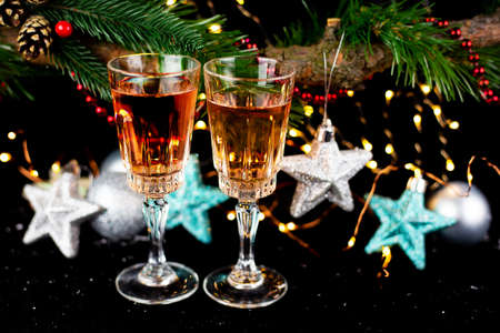 New Year and Christmas decor. Glasses for champagne, toys for the Christmas tree stand on the table...