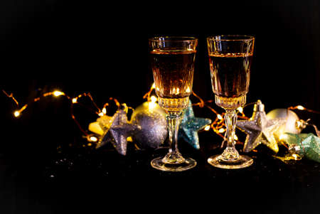 New Year and Christmas decor in the dark. Glasses for champagne, toys for the Christmas tree stand...