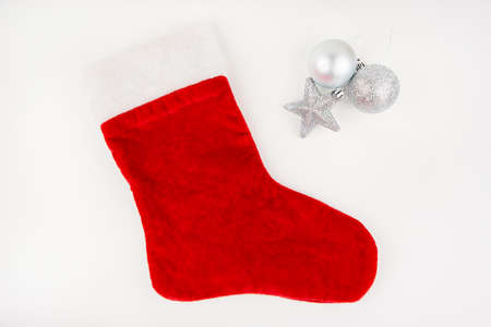 Santa's red stocking isolated on white background together with a toy in the form of a star and a ball. Christmas or holiday conceptの写真素材