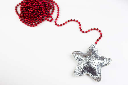Christmas red decoration together with a shiny star in sequins isolated on a white backgroundの写真素材