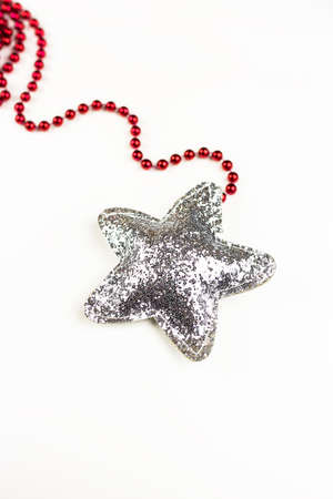 Christmas red decoration together with a shiny star in sequins isolated on a white backgroundの写真素材