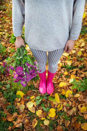 A young woman holds a beautiful blooming bouquet of fresh chrysanthemumsの写真素材