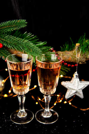 Holiday concept two glasses of champagne, New Year's toys, tree, lights. New Year celebrationの写真素材