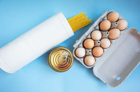 Food set. Coronavirus food delivery. Pasta, eggs, canned food. Contactless delivery of goods. The concept of quarantine and isolation during a pandemicの写真素材